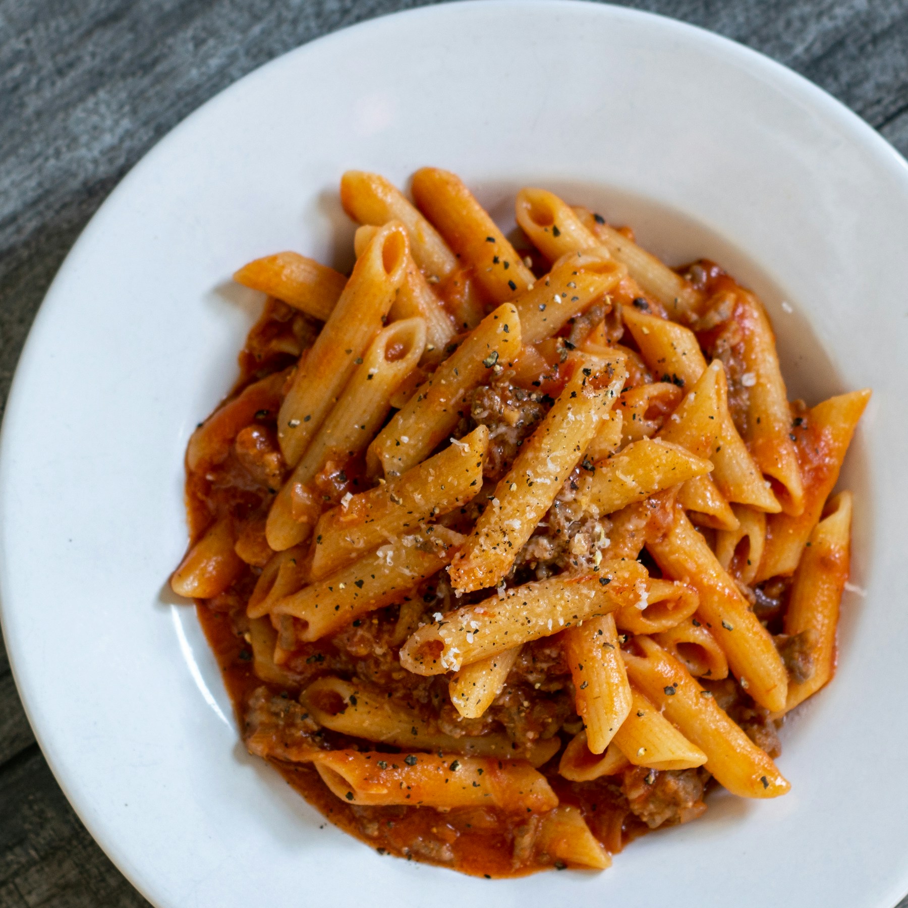 Penne au ragù servies à table